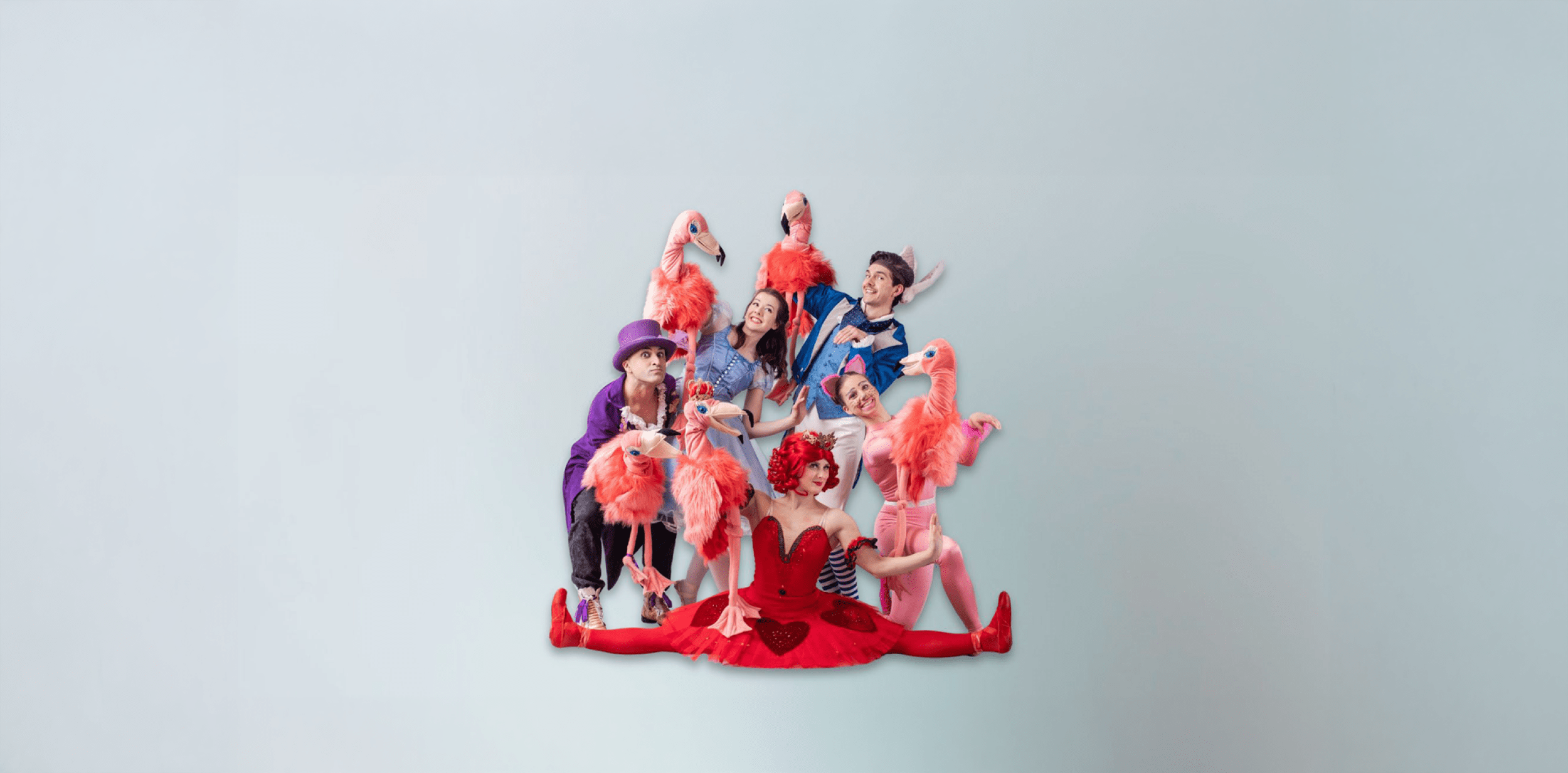 Performers dressed as Alice in Wonderland character posing together as a group.