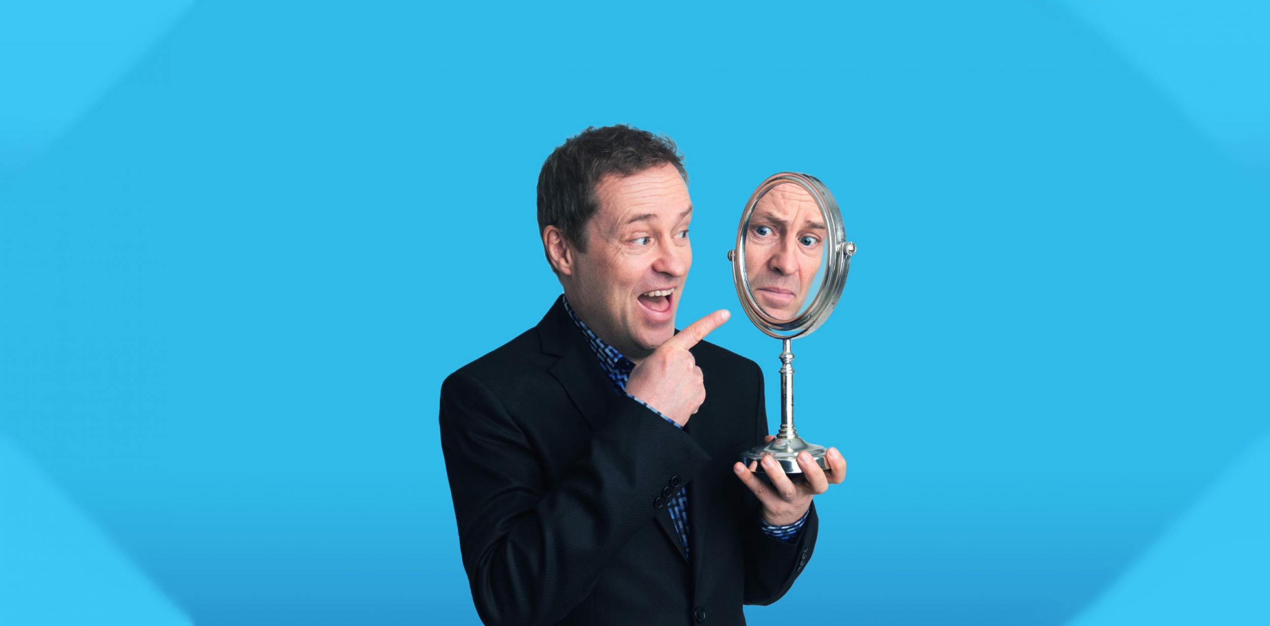 Ardal O'Hanlon looking into a mirror.