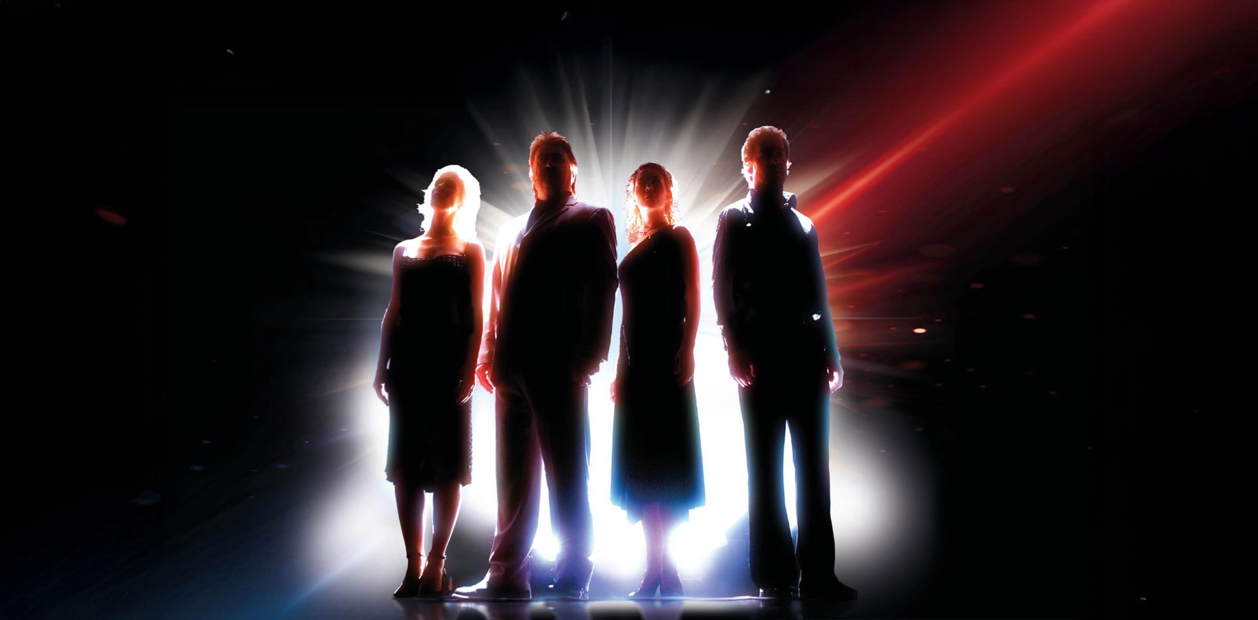 Silhouettes of people standing in the spotlight