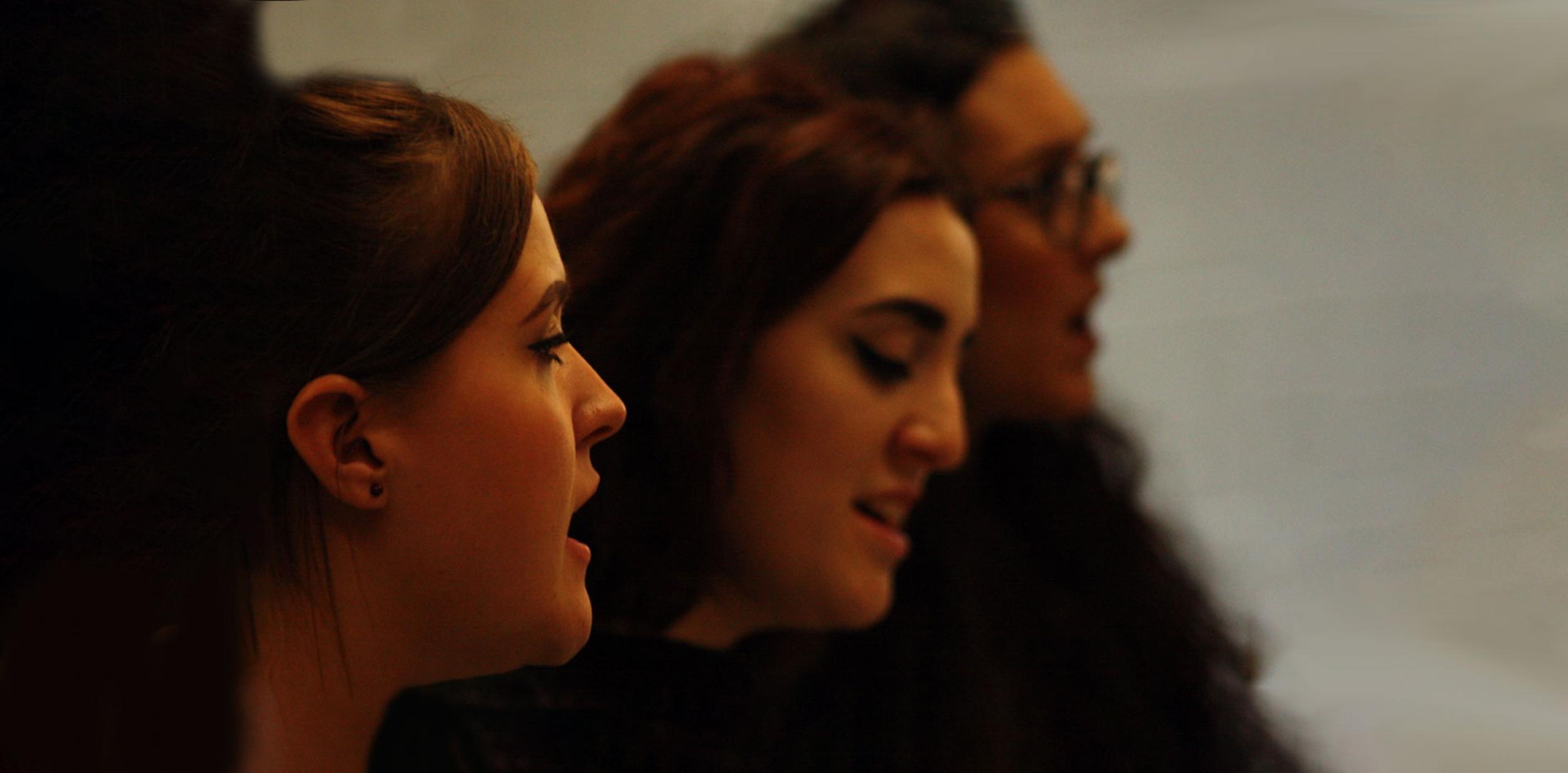 Three young ladies singing.