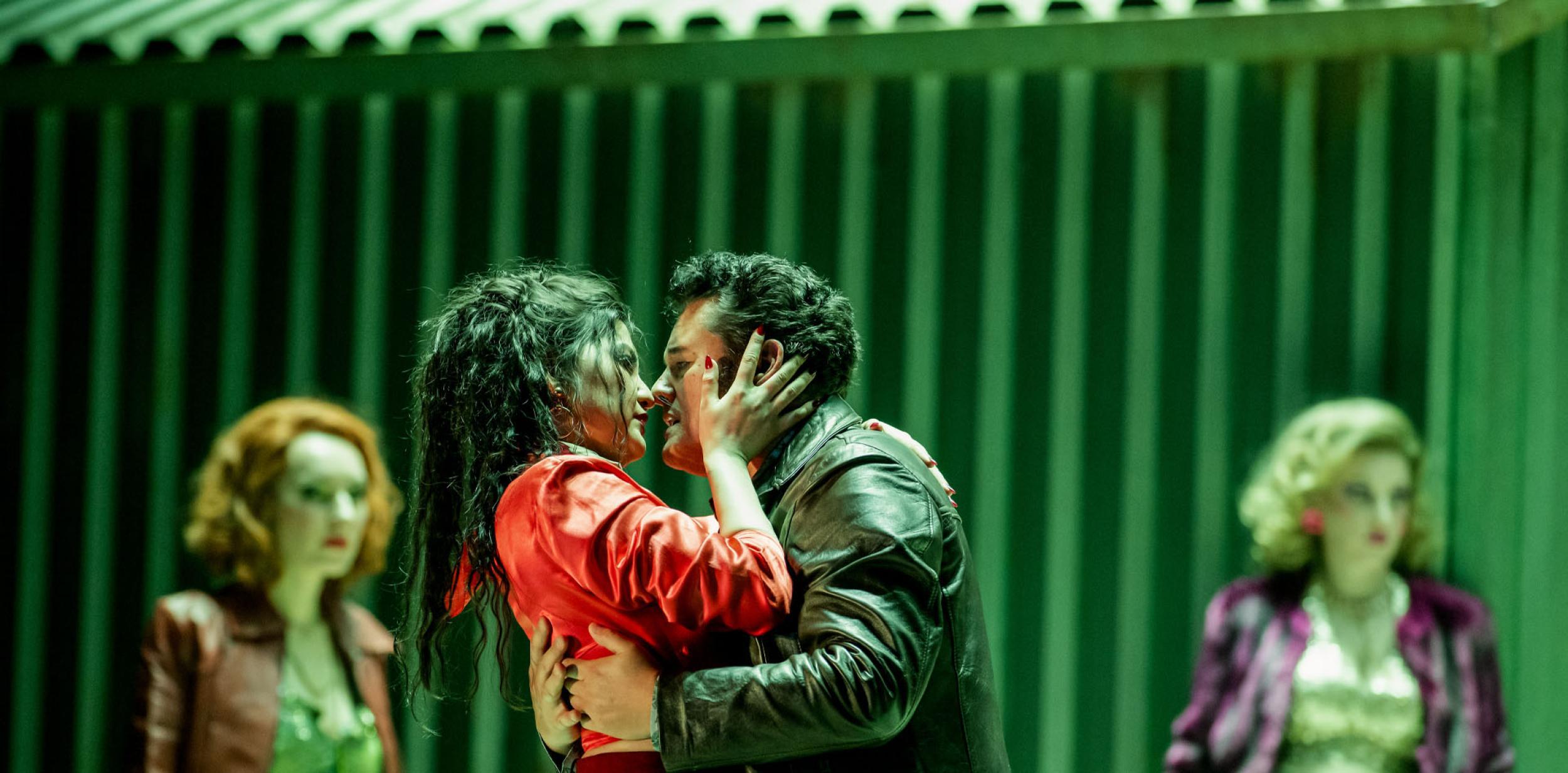 A woman and a man embracing in green lighting.