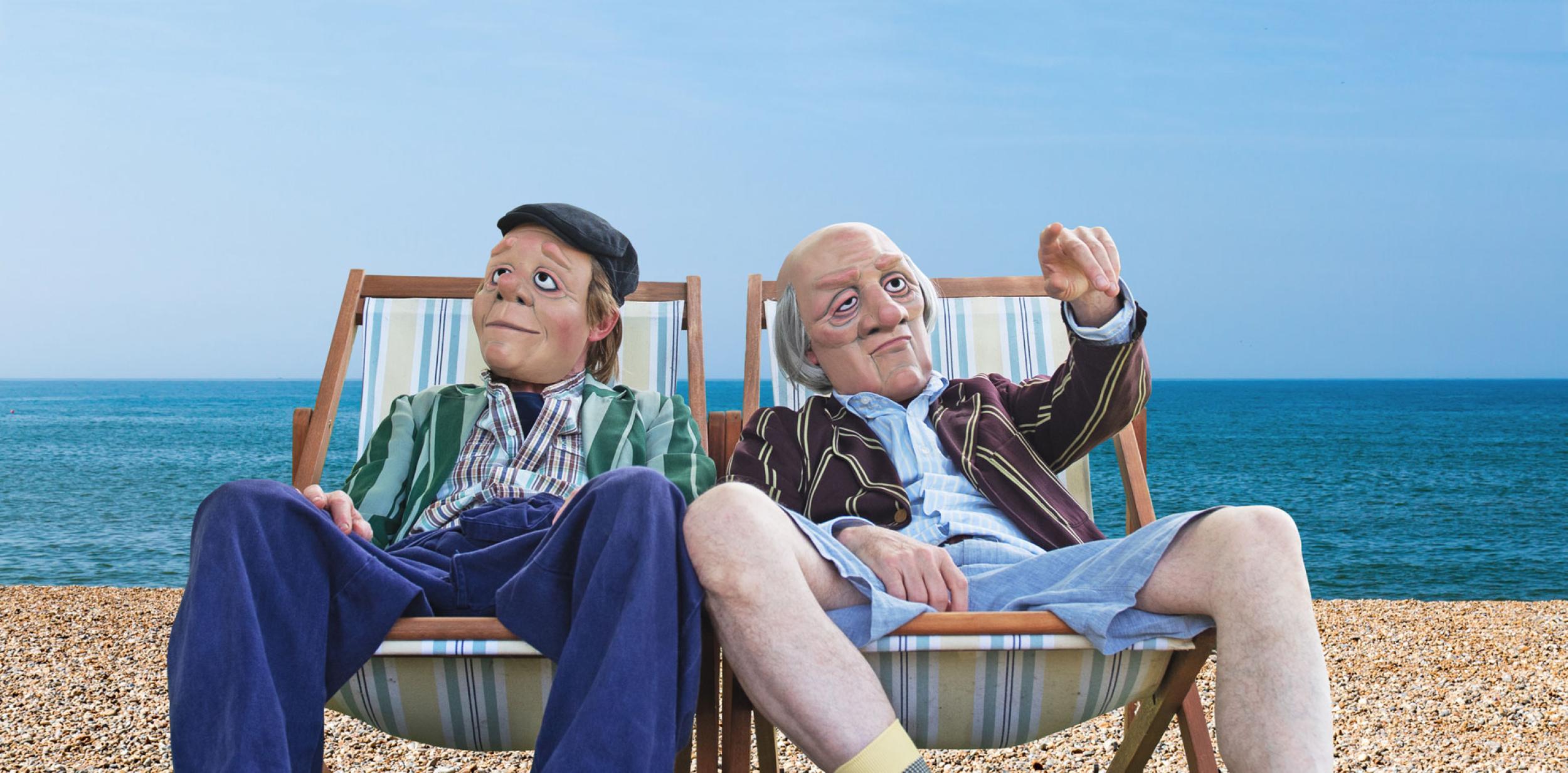 Two people on deckchairs at the beach