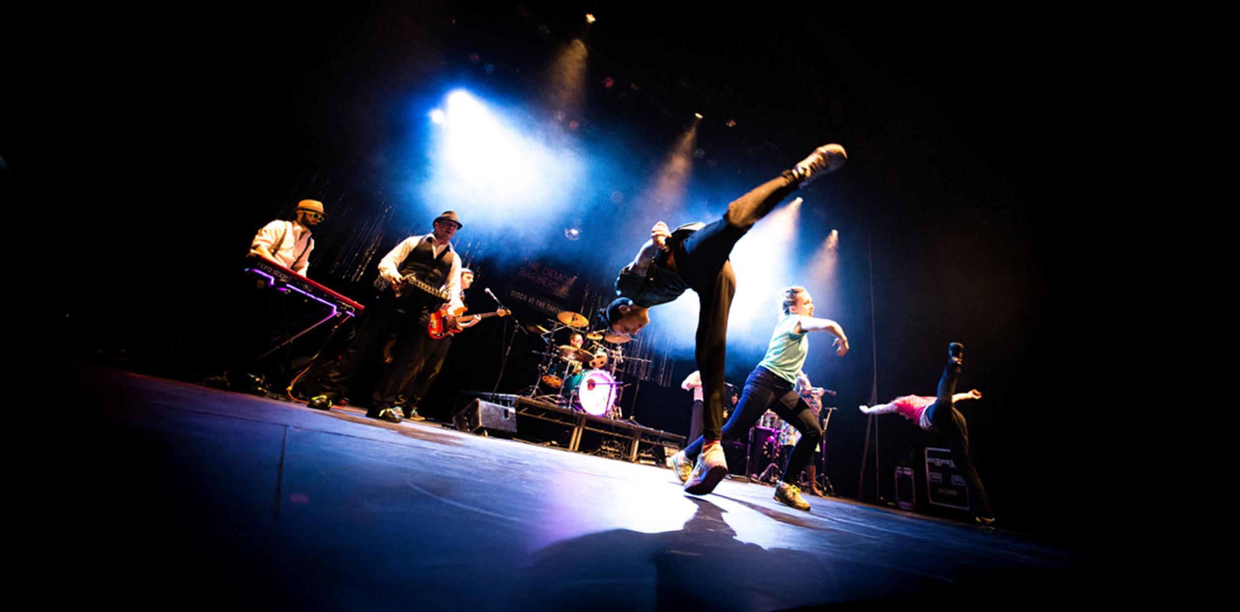 Breakdancers performing in front of a live band