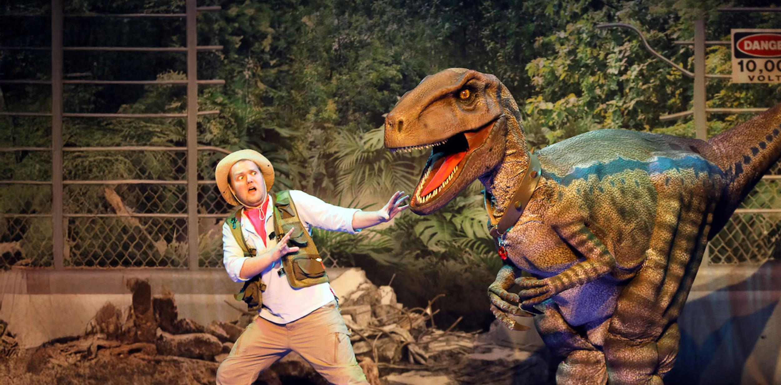 A man and a large dinosaur puppet