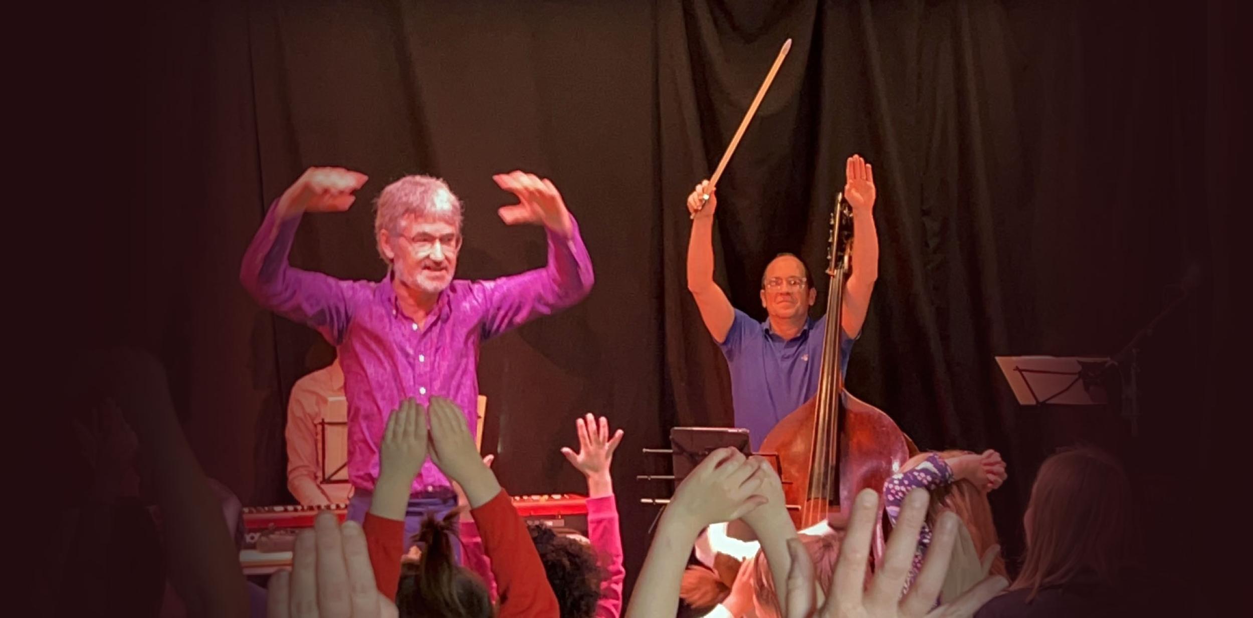 Two musicians performing to a large crowd of young people