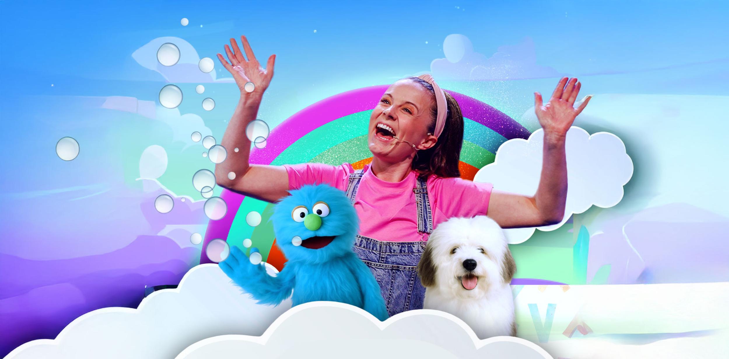 A lady standing next to two puppets surround by clouds and a colourful background