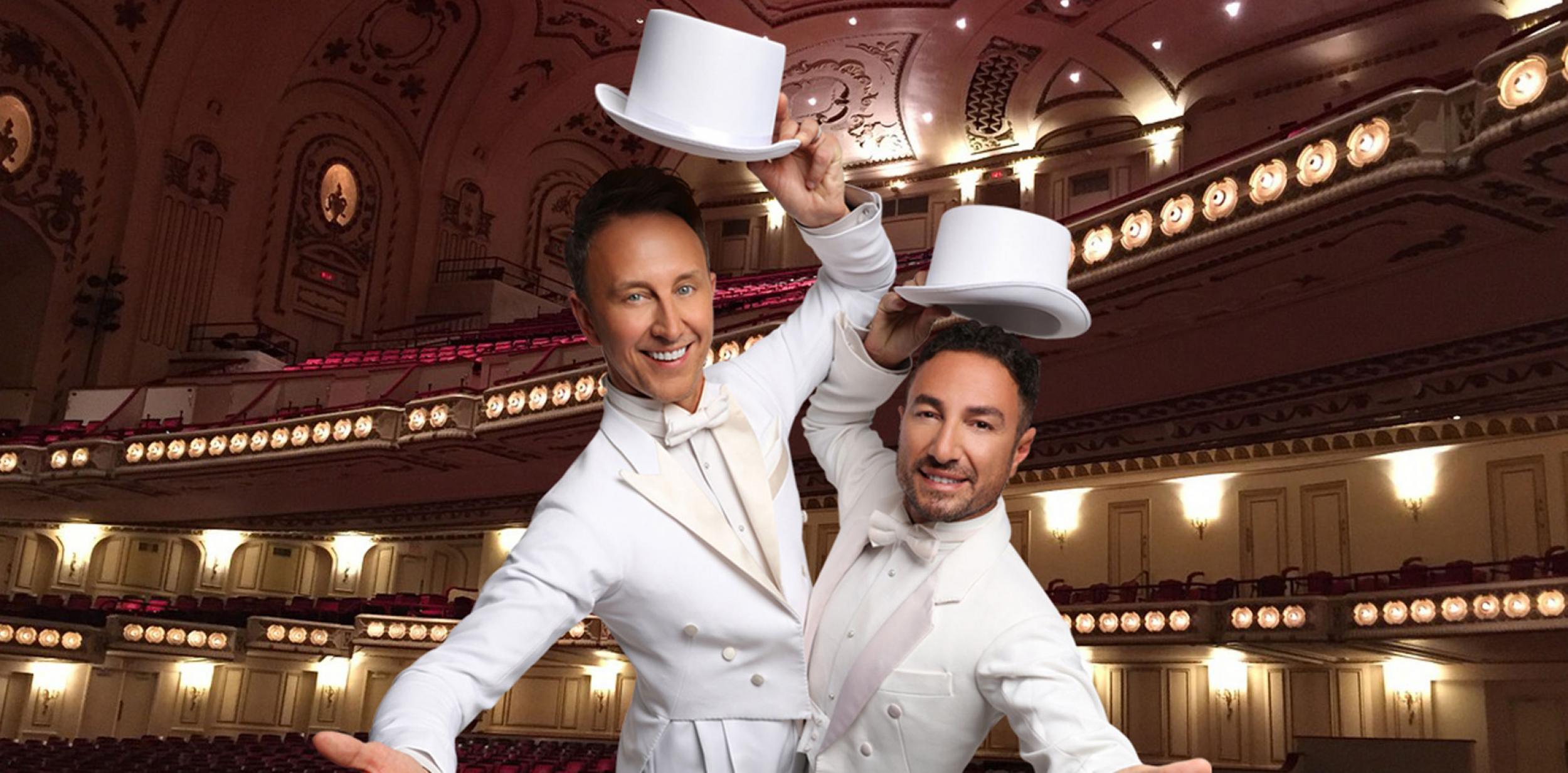 Male dancers in white suits taking off their top hats in a theatre auditorium