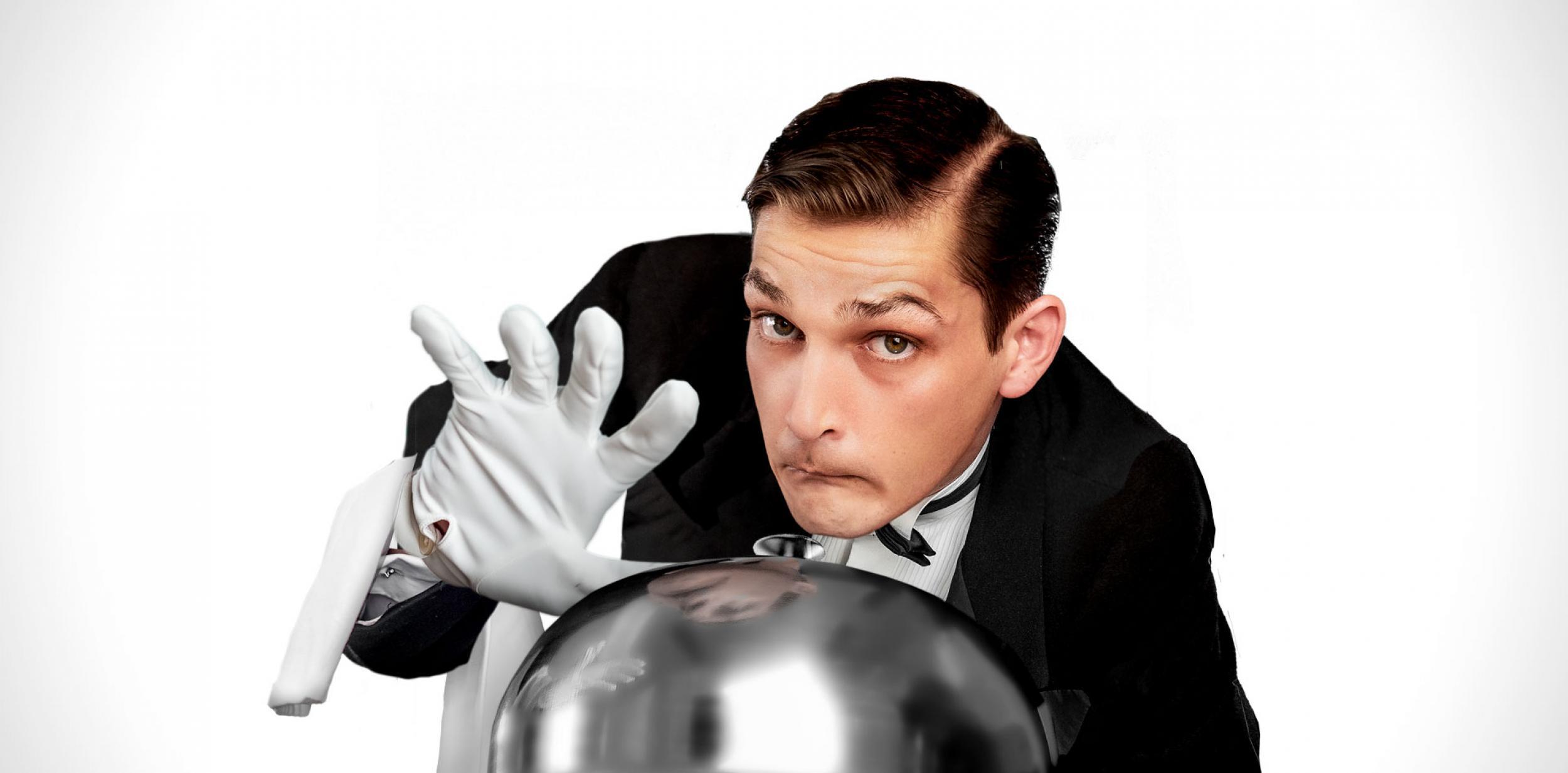 A butler holding a cloche serving dish.