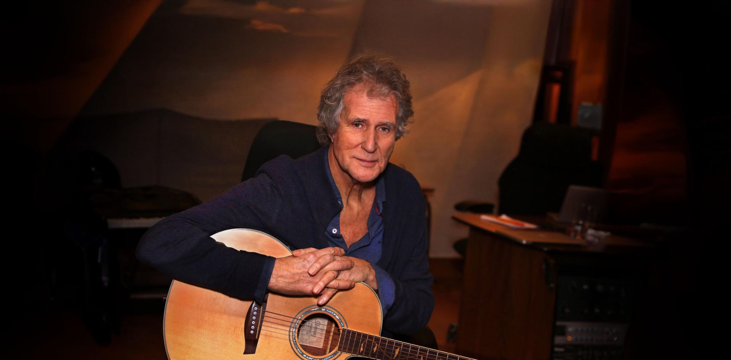 John Illsley holding a guitar