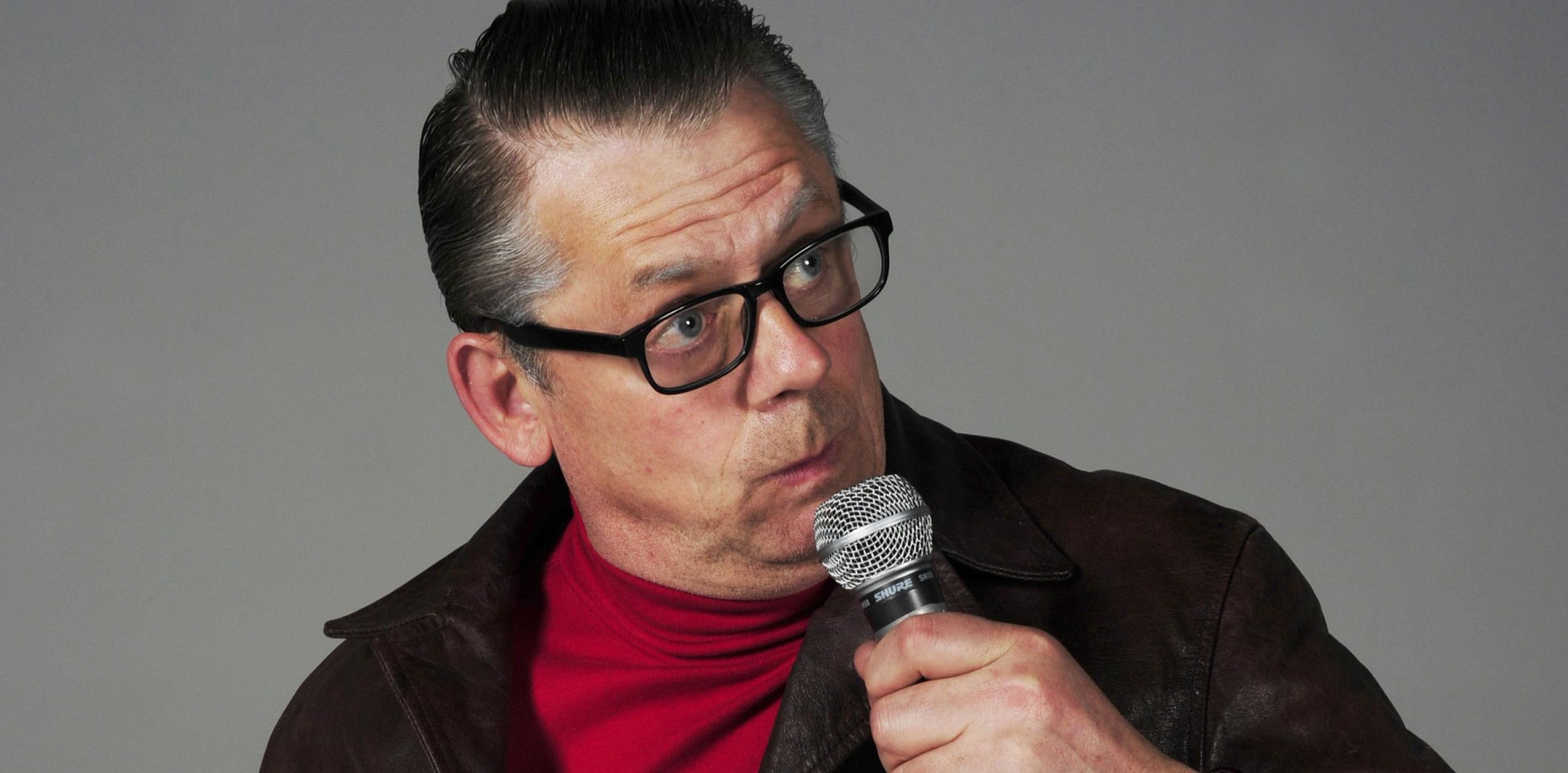 John Shuttleworth holding a microphone