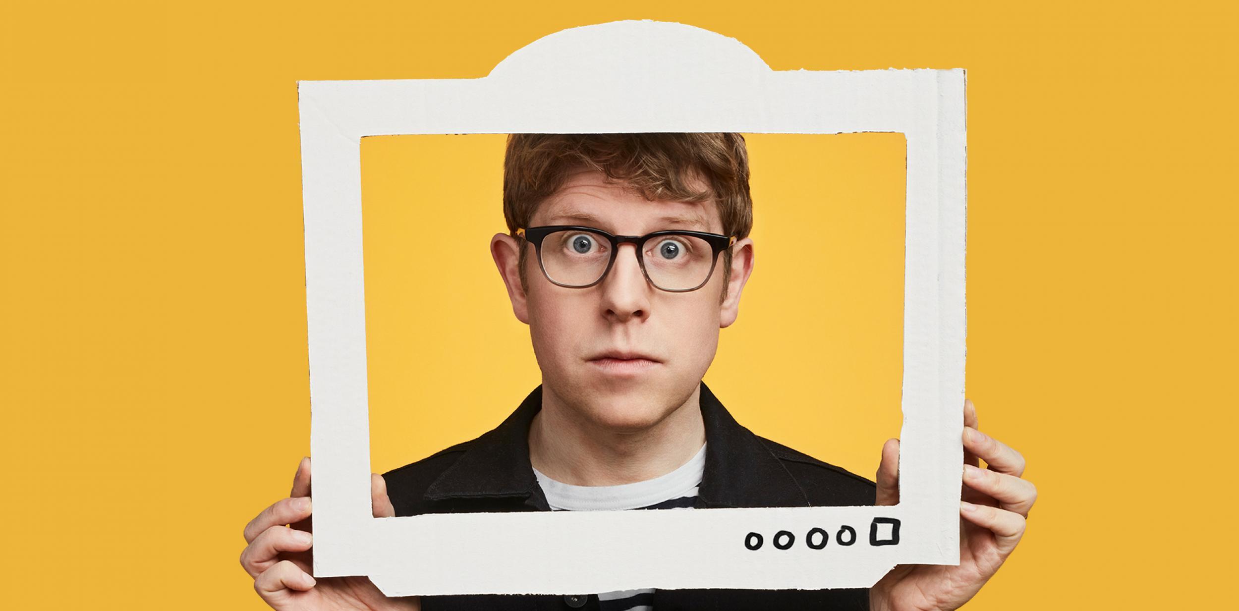 Josh Widdicombe looking through cardboard TV