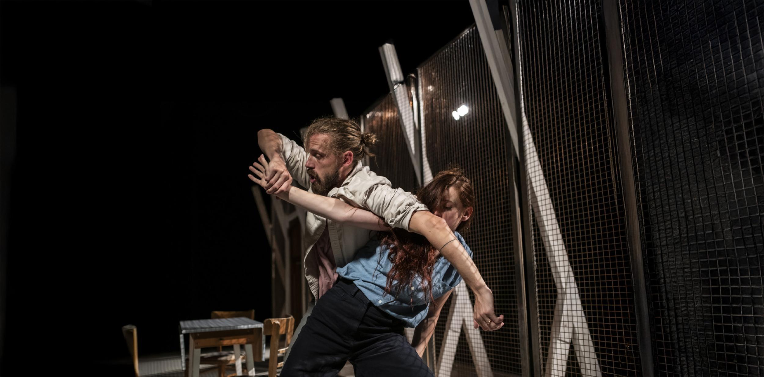 Juilet and Romeo performers dancing on dark set.