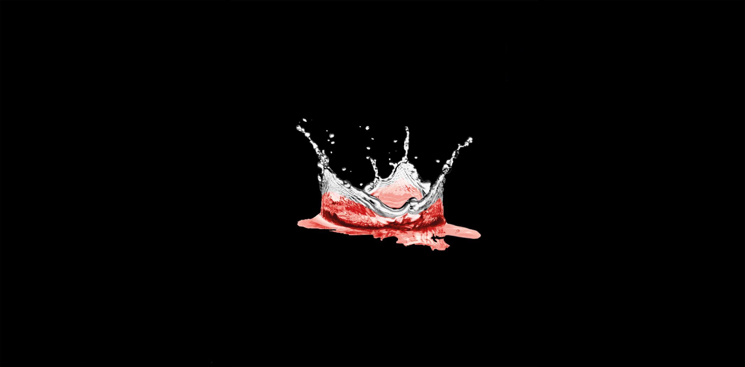 Red tinged water splashing to form the shape of a crown