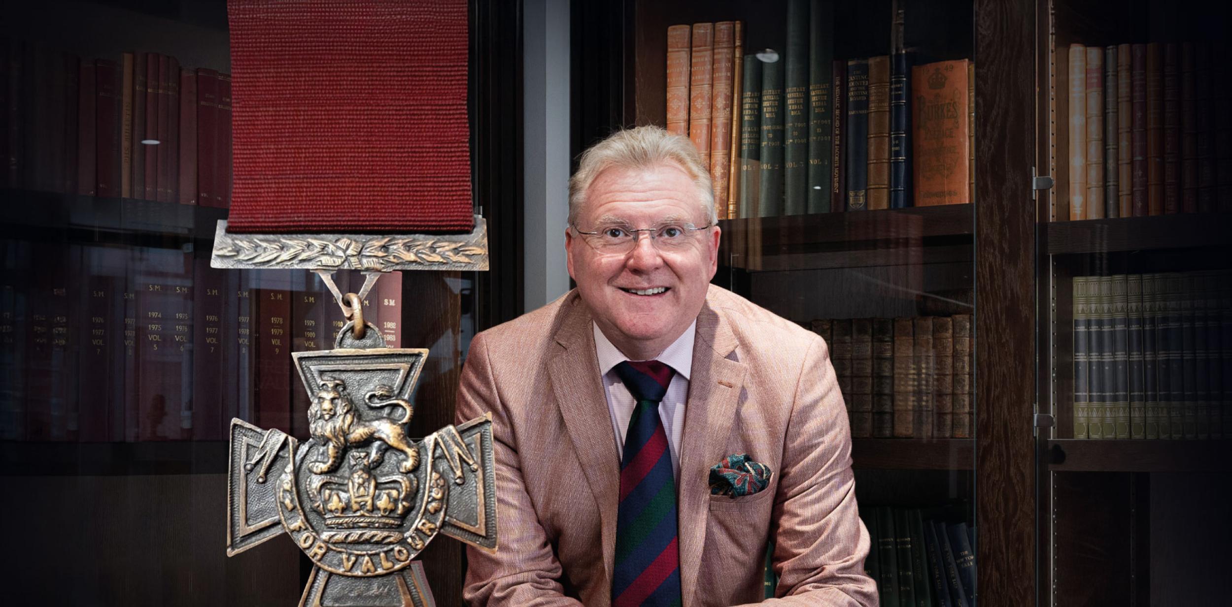 Mark Smith standing in front of a large bookcase
