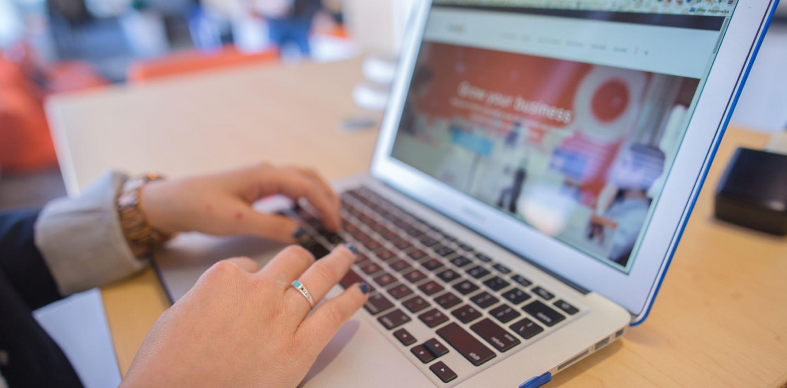 Hands typing on a laptop