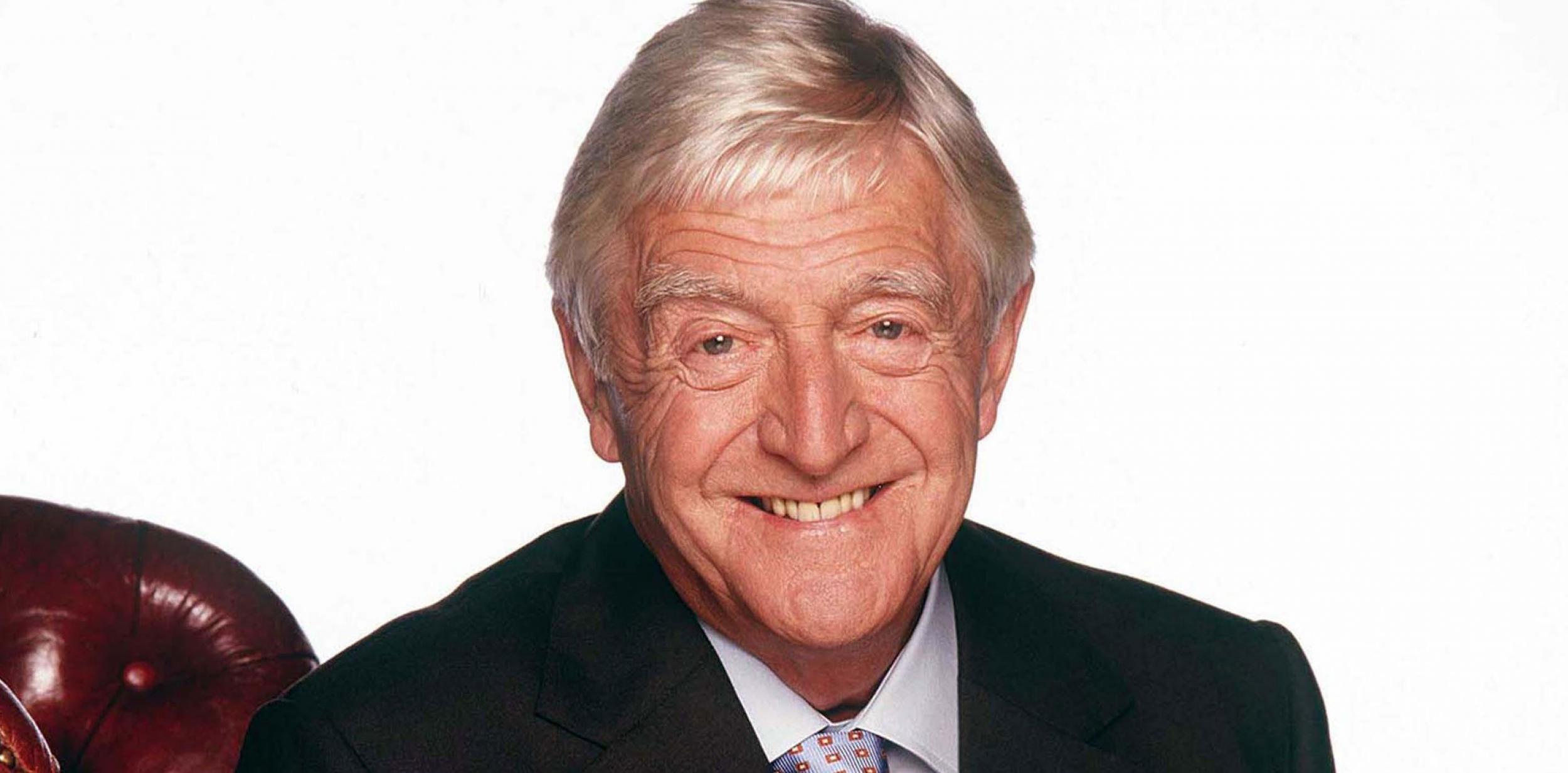 Sir Michael Parkinson sitting on a chair