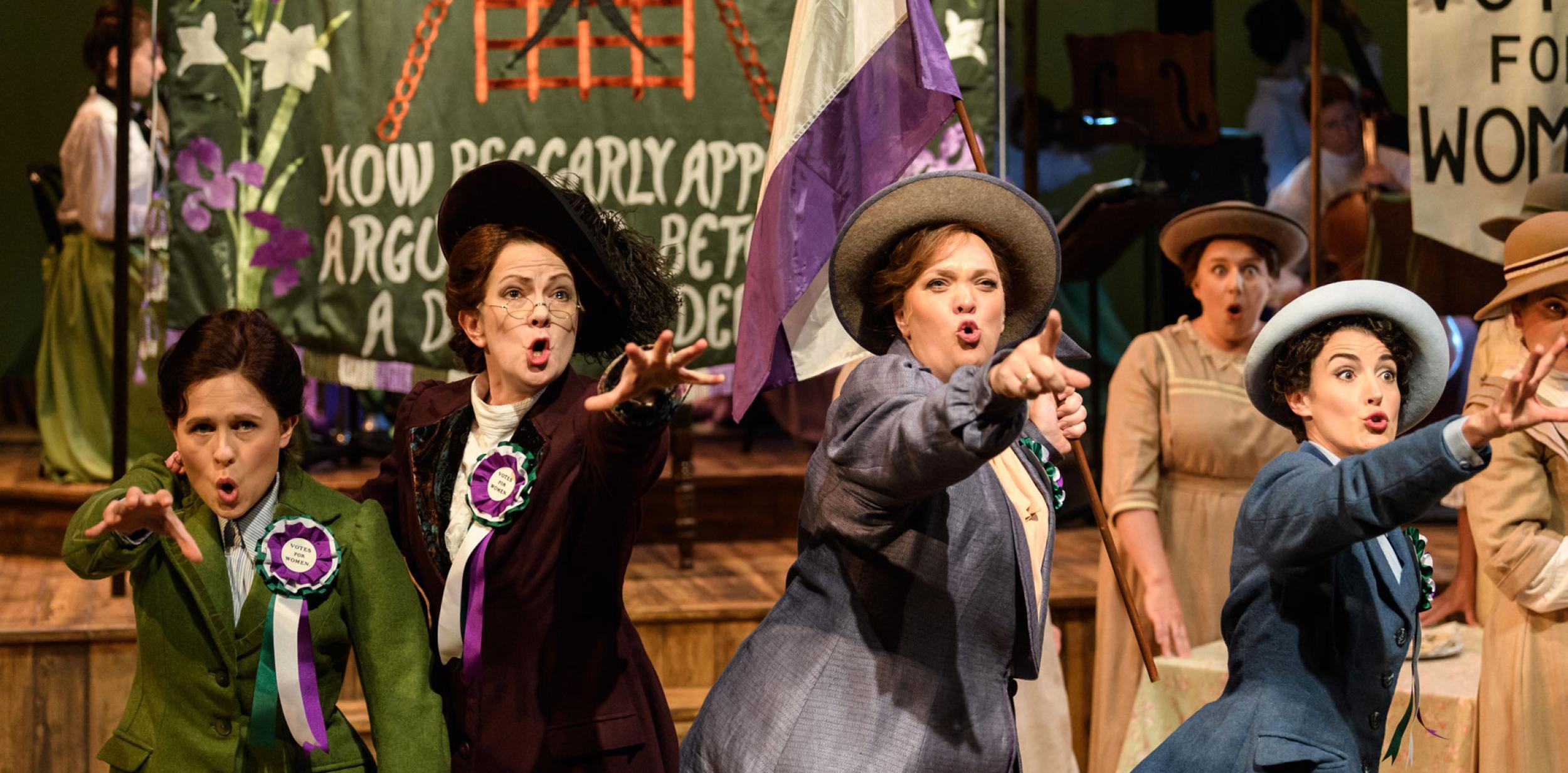 Suffragette characters from the opera, Rhondda rips it up, pointing out to the audience.