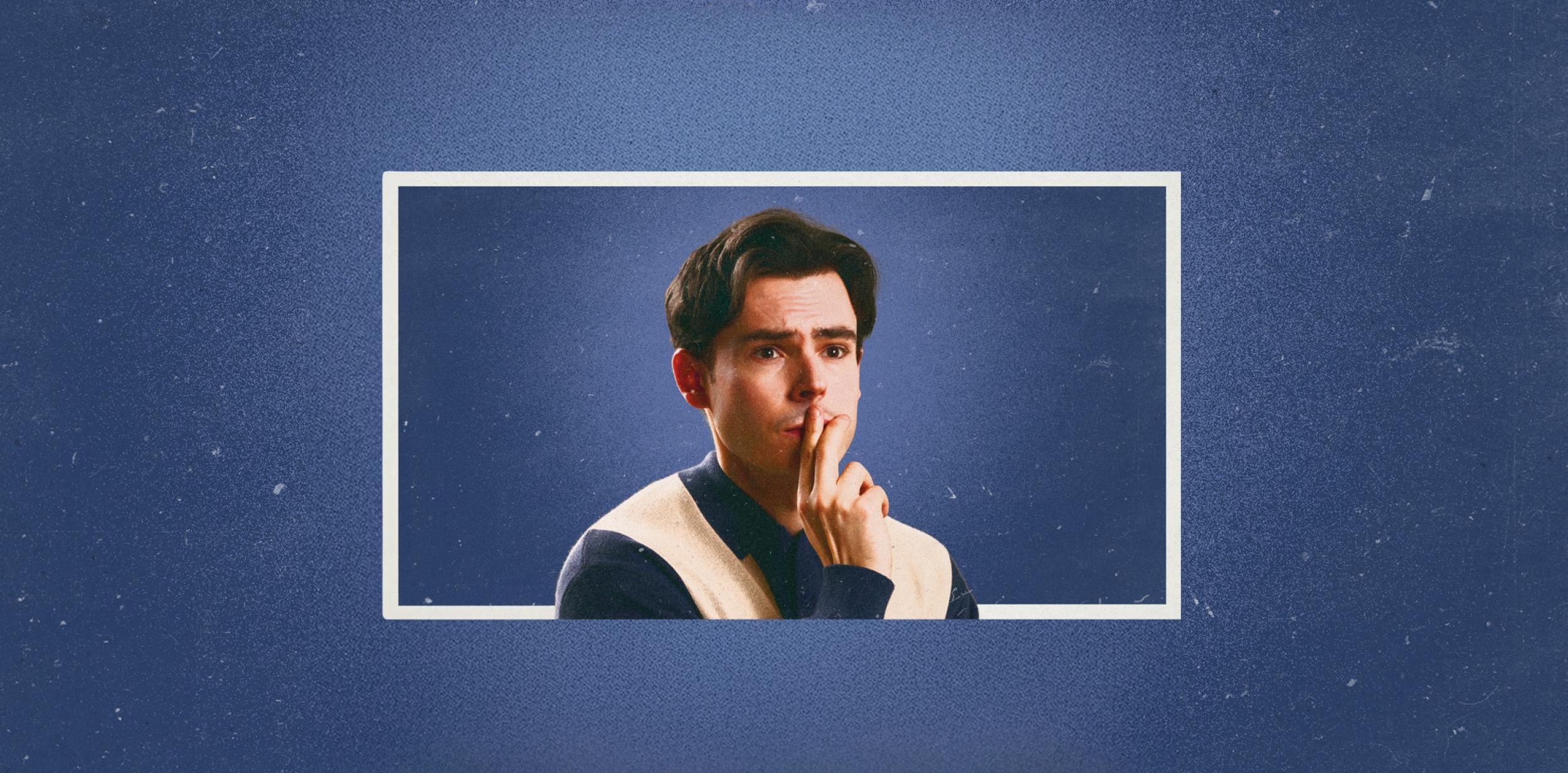 Rhys James pondering in front of a blue background