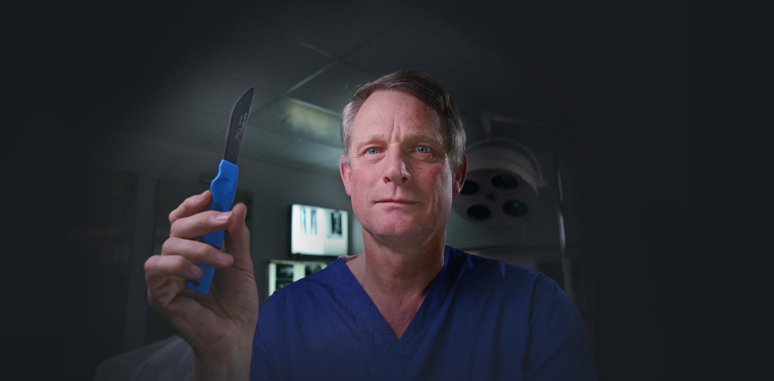 Dr Richard Shepherd in scrubs with a scalpel