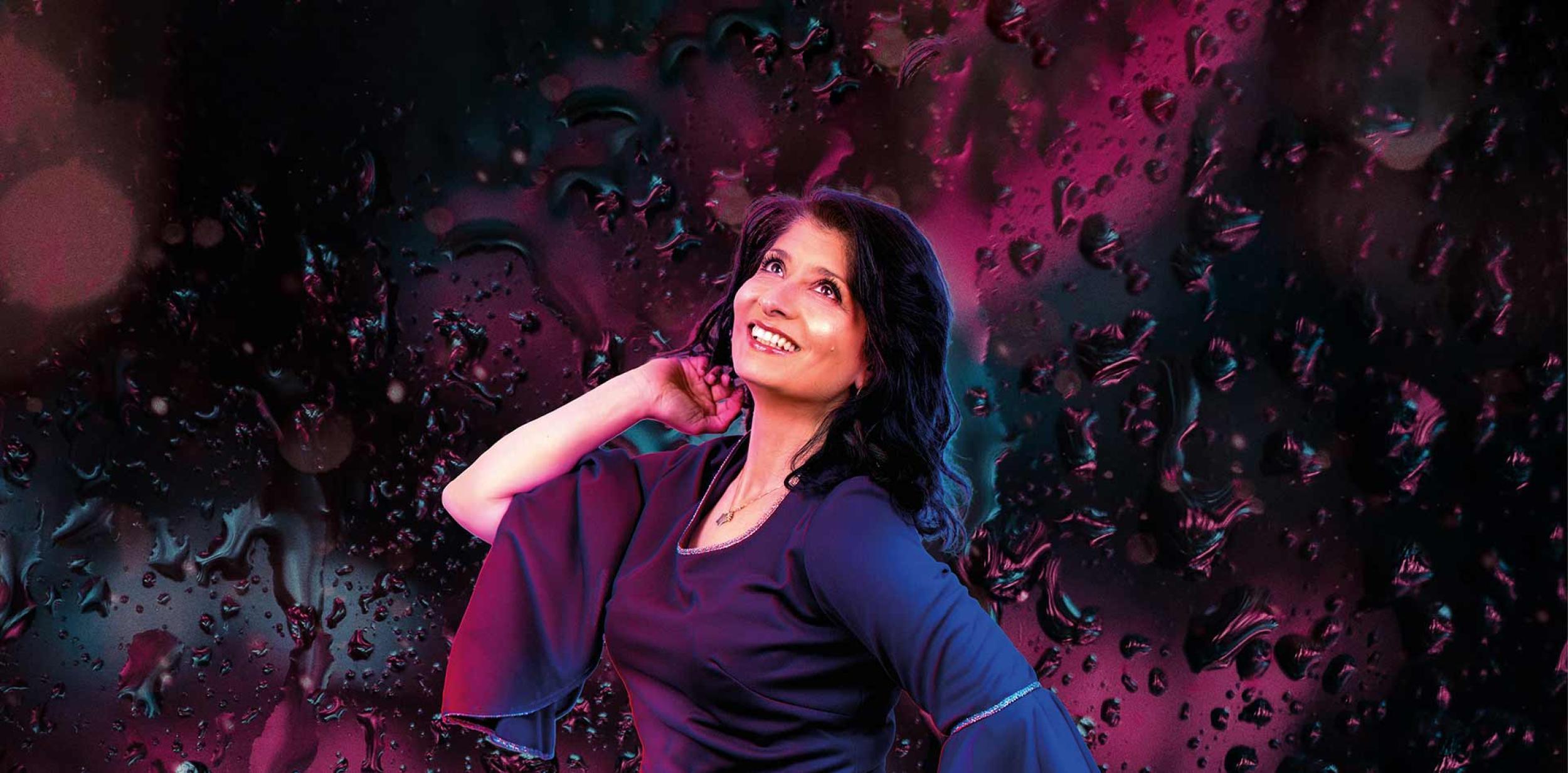 Shaparak Khorsandi posing in front of purple disco background