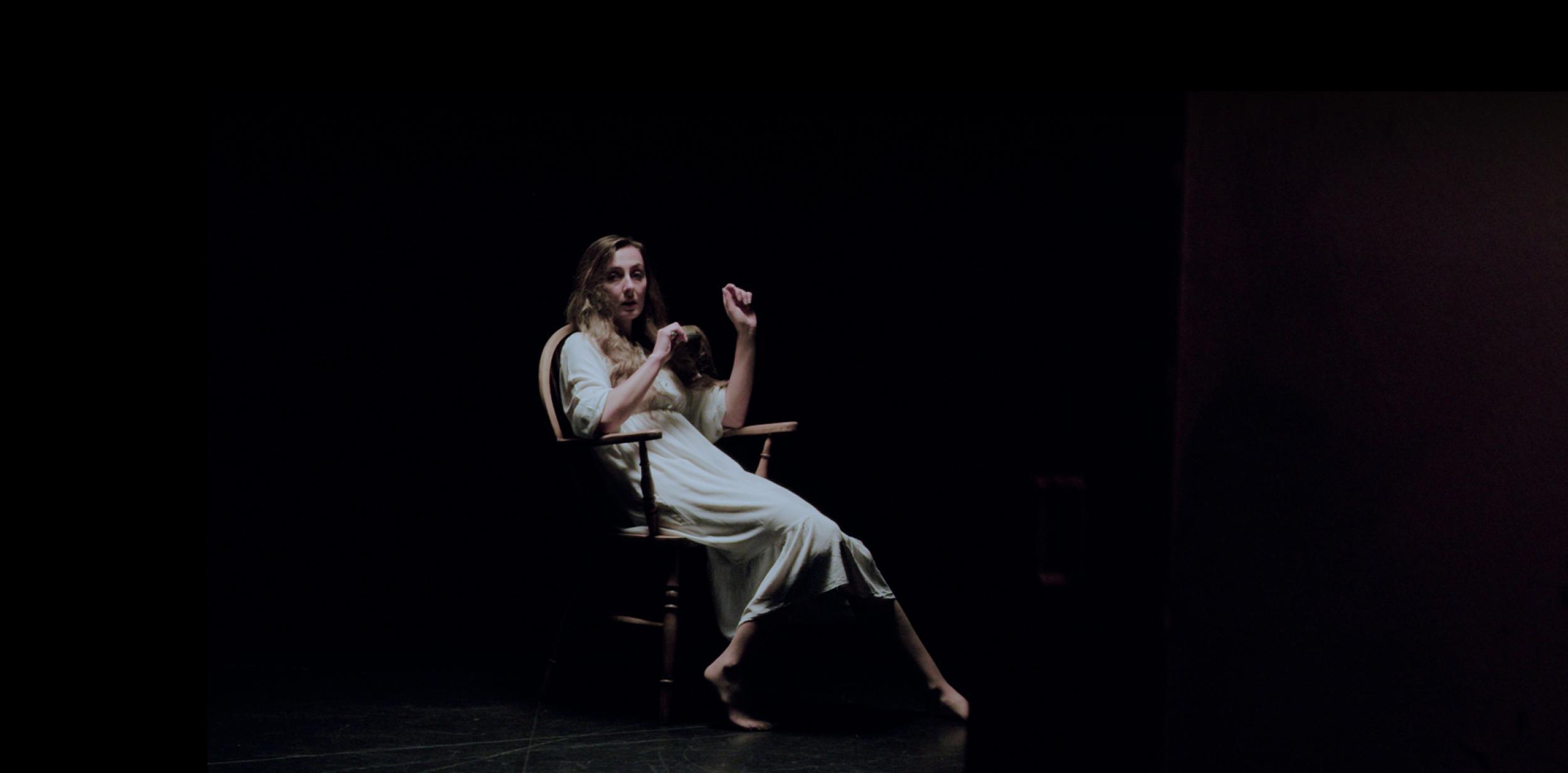 Woman sitting in a chair in the dark