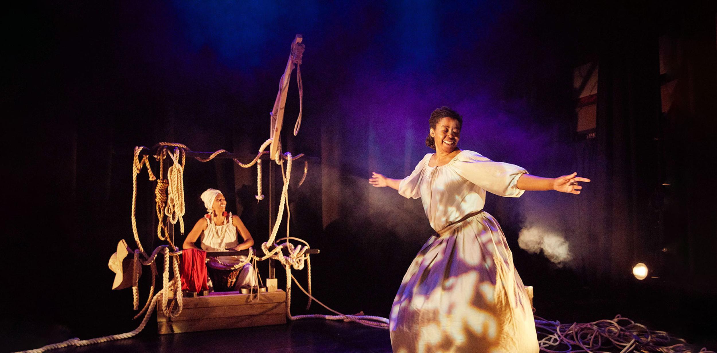 One person dancing, another person sitting down surrounded by rope