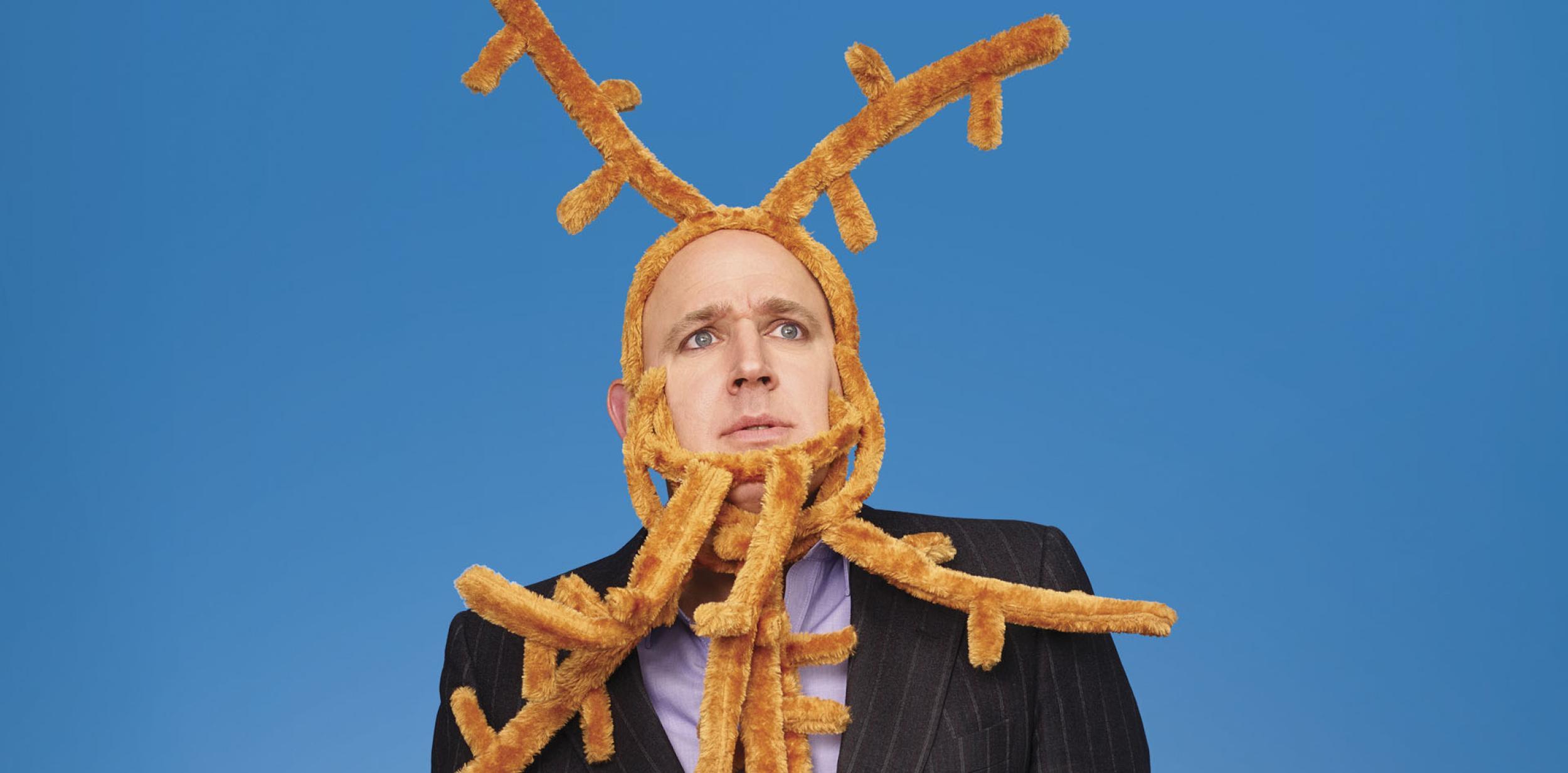 Tim Vine in suit with felt antlers on