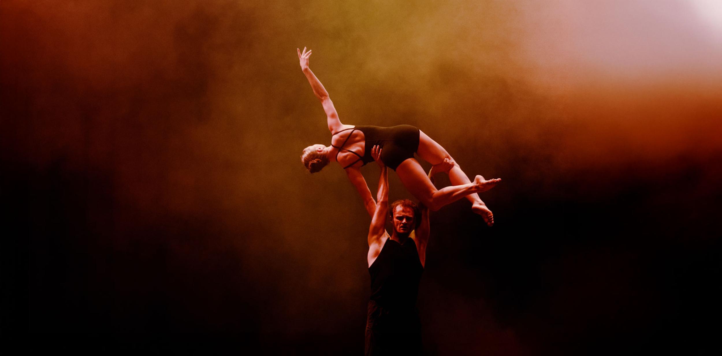A dancer lifting another dancer into the air