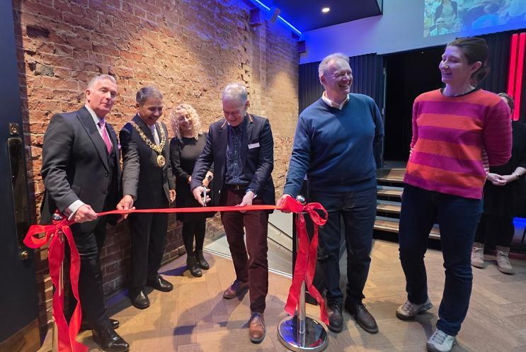 Group gathered for ribbon cutting in front of new toilets