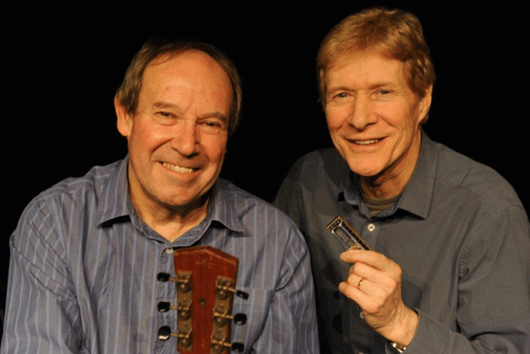 Paul Jones and Dave Kelly smiling with a dark background.