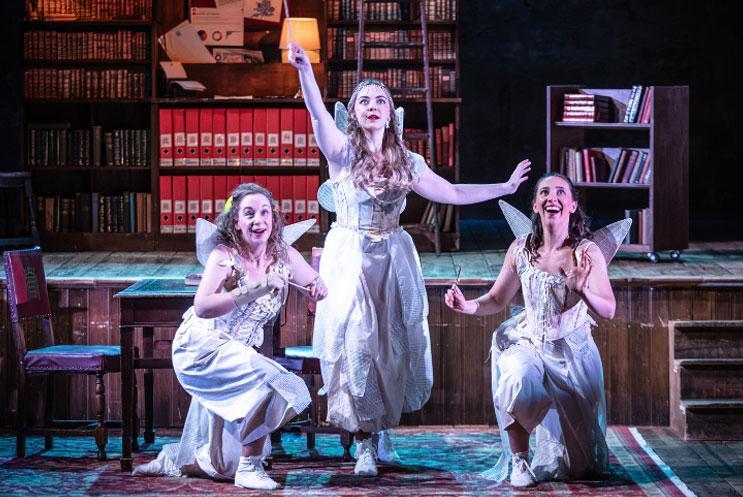 Three people on a stage dressed as fairies