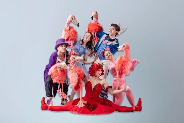 Performers dressed as Alice in Wonderland character posing together as a group.
