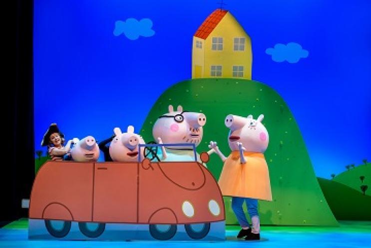 Peppa Pig and family on stage in a car