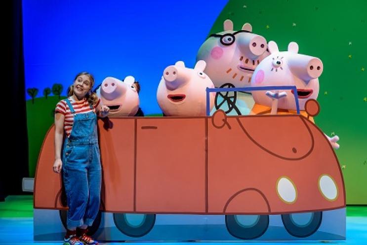peppa Pig characters and actress in a car on stage