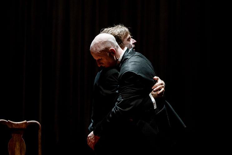 Two men in black tie hugging each other
