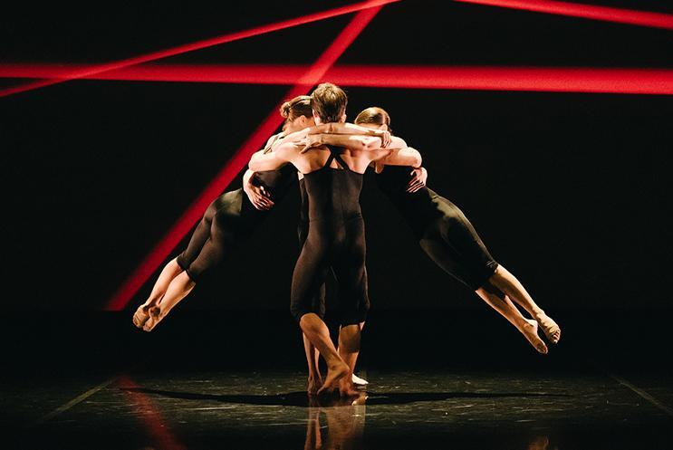 Three people dancing amongst red stripes