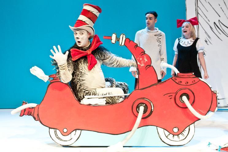 The cat in a 2D red car waving at the audience