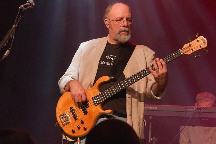 A person playing a bass guitar