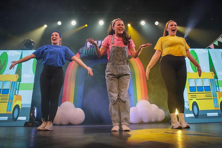 Three performers dancing on stage.