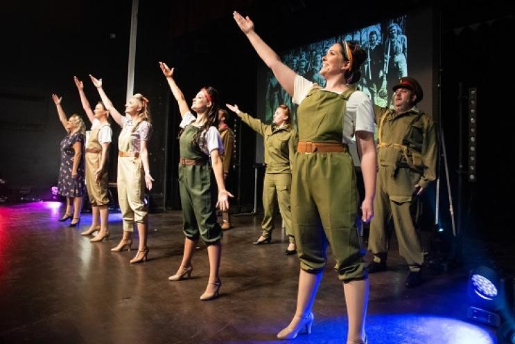 singers dressed as 1940s army girls on  the stage