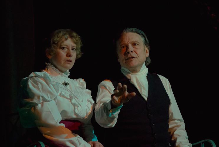 A man and a woman on a bench looking off into the distance.