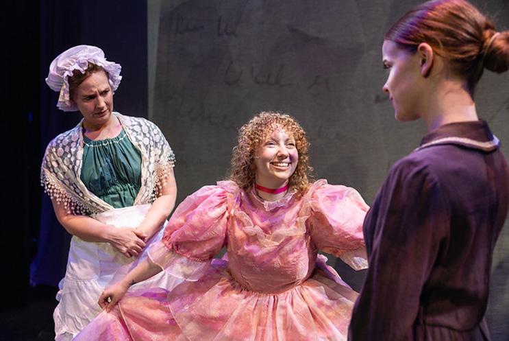 A performer in a big pink dress doing a curtsey to Jane Eyre and smiling.