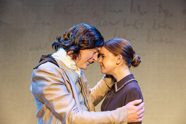 Two performers, holding each other and the foreheads pressed together.
