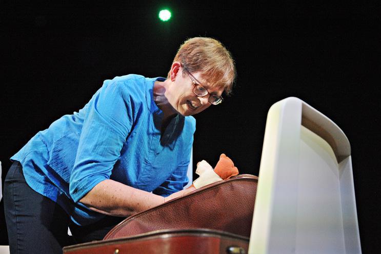 A person bent over a chair cradling a cuddly toy