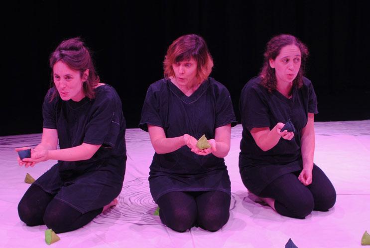 3 females in black kneeling on a white mat