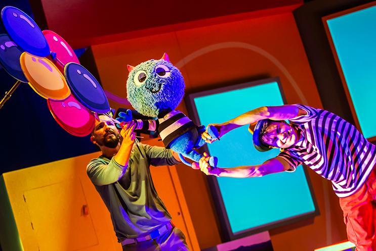 Performer  trying to not let puppet monster flyer away on balloons