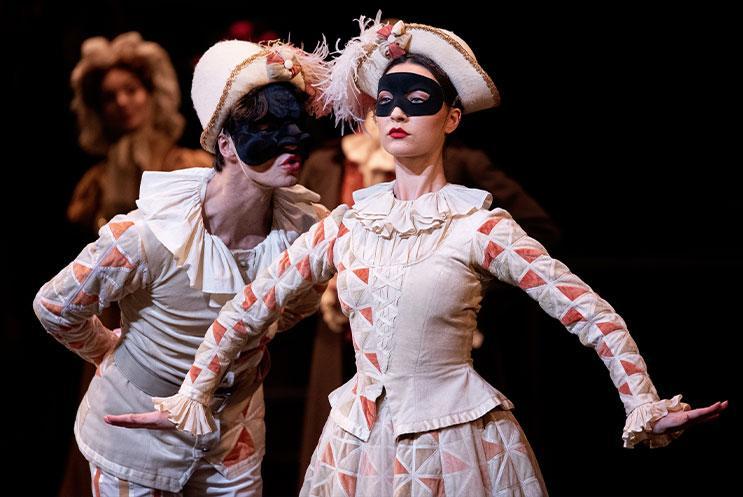 Two people wearing masks and ball costumes