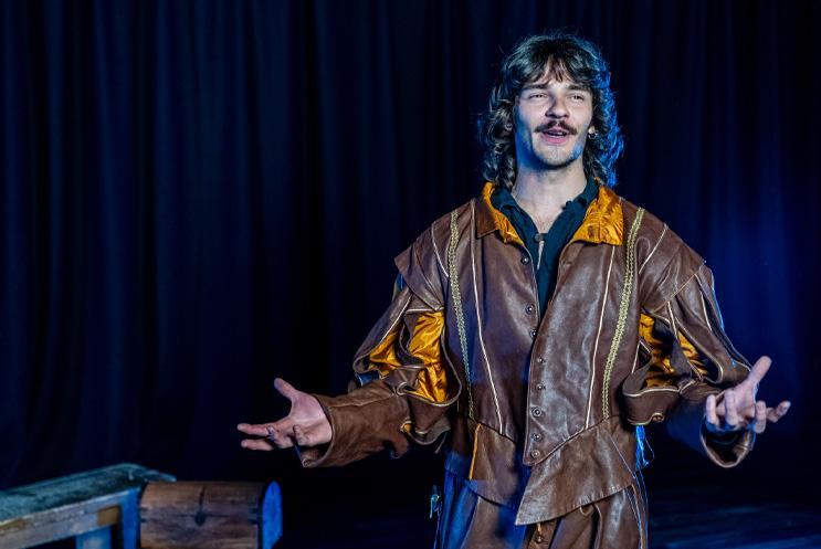 A man in rusty coloured jacket holding out his hands