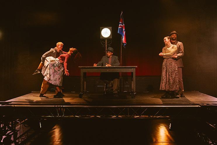 Performers on stage in low lighting.