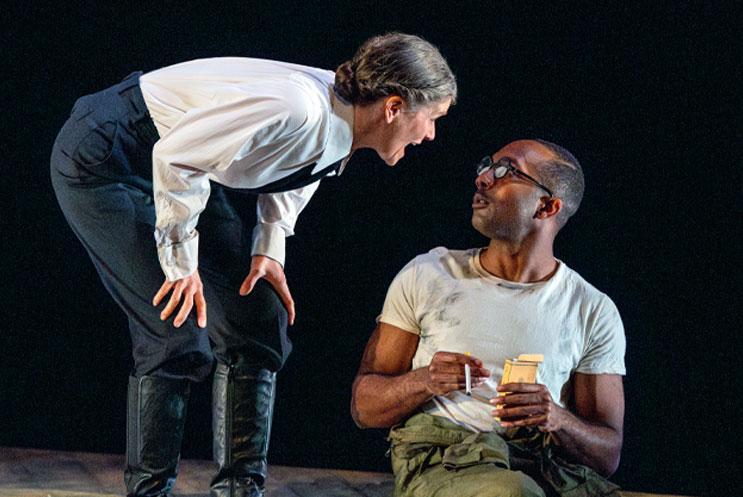 A woman leaning forward talking to a man sitting on the floor
